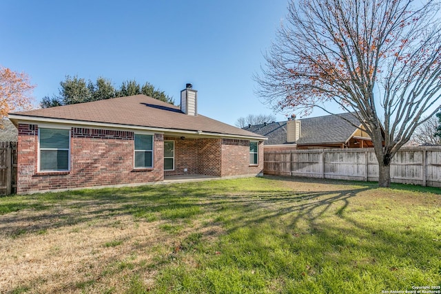 back of property with a yard and a patio area