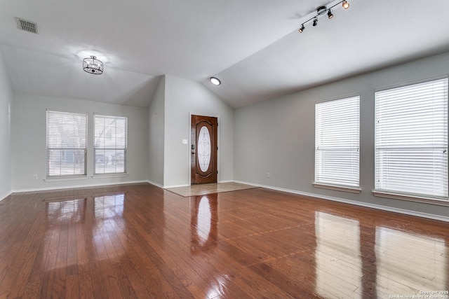 foyer entrance featuring hardwood / wood-style flooring, lofted ceiling, and a healthy amount of sunlight