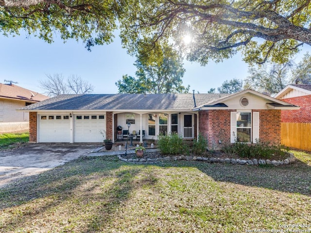 ranch-style home with a garage, covered porch, and a front lawn