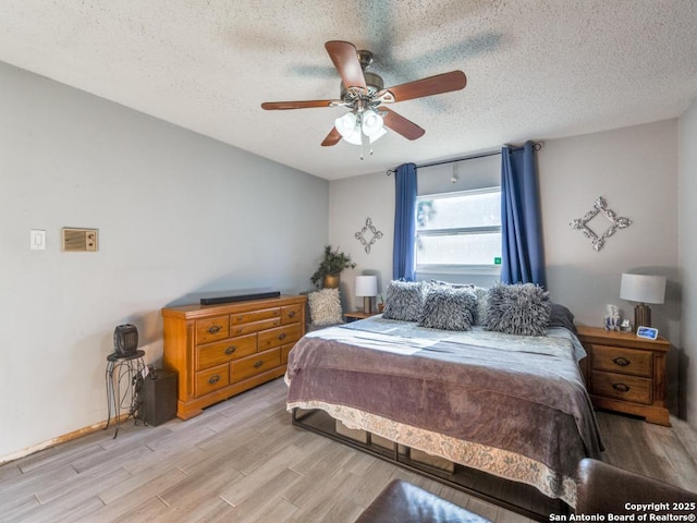 bedroom featuring a textured ceiling, light hardwood / wood-style flooring, and ceiling fan