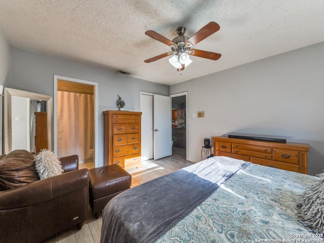 bedroom with ceiling fan, a closet, a textured ceiling, and light wood-type flooring