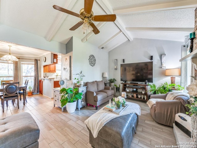 living room featuring ceiling fan with notable chandelier, lofted ceiling with beams, and a textured ceiling