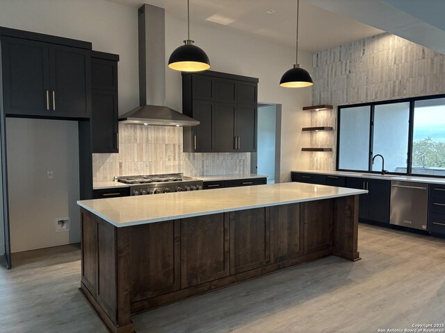 736 Johanna Ridge Rd, Bulverde, TX 78163 - kitchen featuring appliances with stainless steel finishes, decorative light fixtures, backsplash, a center island, and wall chimney exhaust hood