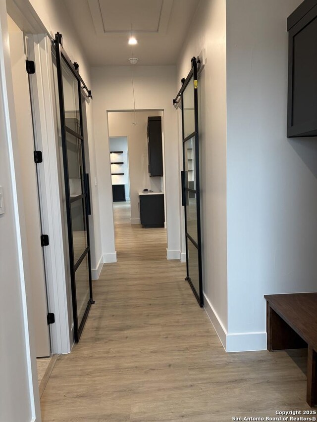 736 Johanna Ridge Rd, Bulverde, TX 78163 - hall with a barn door and light hardwood / wood-style floors