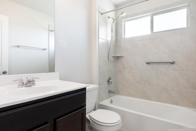 full bathroom featuring vanity, tiled shower / bath, and toilet