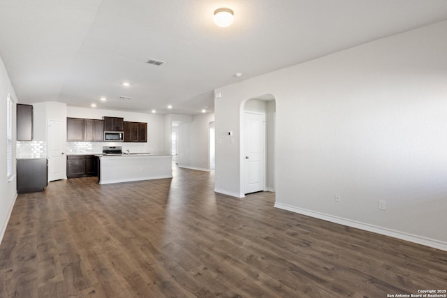 unfurnished living room with dark hardwood / wood-style flooring and vaulted ceiling