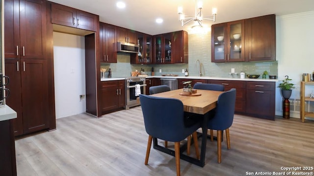 kitchen featuring a chandelier, appliances with stainless steel finishes, ventilation hood, and light hardwood / wood-style flooring