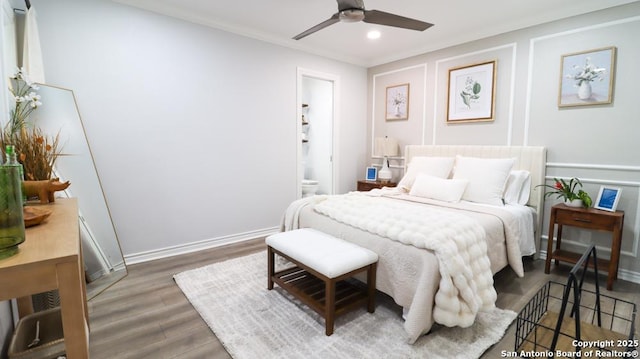 bedroom featuring dark hardwood / wood-style flooring, connected bathroom, crown molding, and ceiling fan