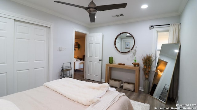 bedroom featuring dark hardwood / wood-style flooring, ornamental molding, a closet, and ceiling fan