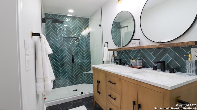 bathroom with tile patterned flooring, backsplash, vanity, and a shower with door