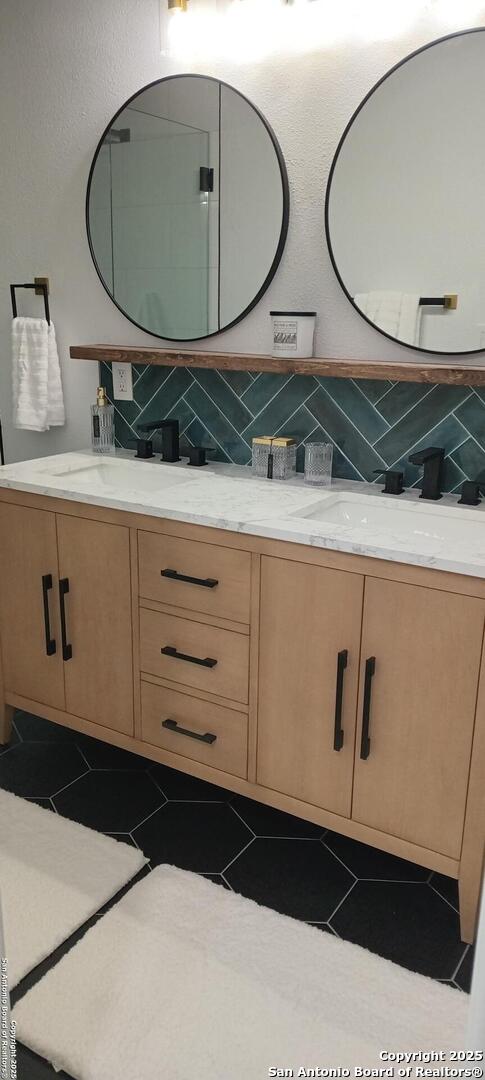 bathroom featuring vanity, tile patterned flooring, and decorative backsplash