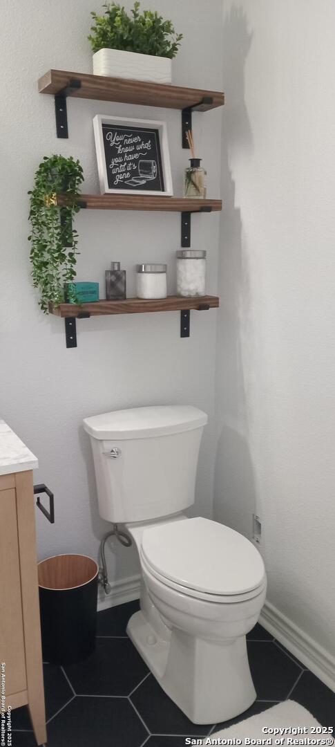 bathroom featuring vanity, toilet, and tile patterned flooring