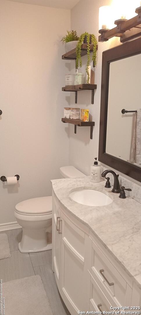 bathroom with vanity, tile patterned floors, and toilet