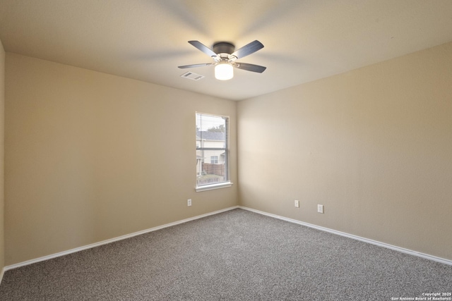 carpeted empty room with visible vents, baseboards, and ceiling fan