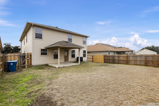 rear view of property featuring central AC unit, a patio area, and a lawn