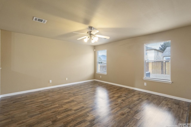 empty room with dark hardwood / wood-style flooring and ceiling fan