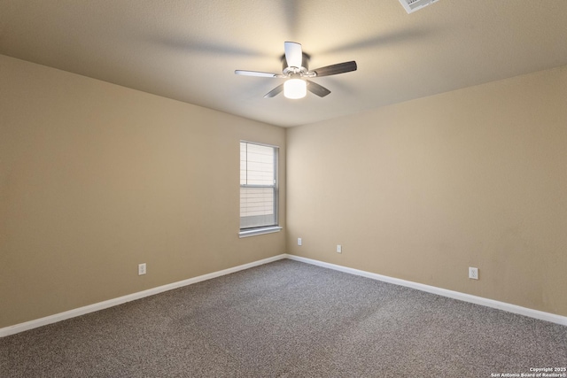 empty room with a ceiling fan, dark colored carpet, and baseboards