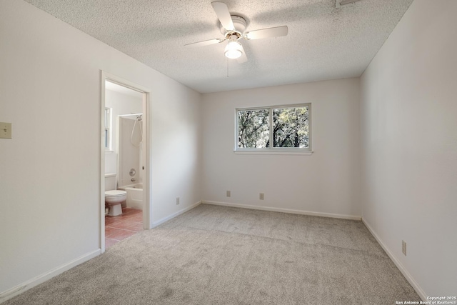 carpeted spare room with a textured ceiling and ceiling fan