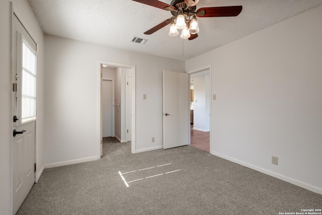 unfurnished bedroom with carpet flooring, a textured ceiling, and ceiling fan