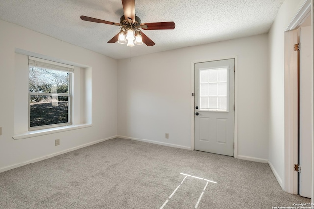 carpeted empty room with ceiling fan and a textured ceiling