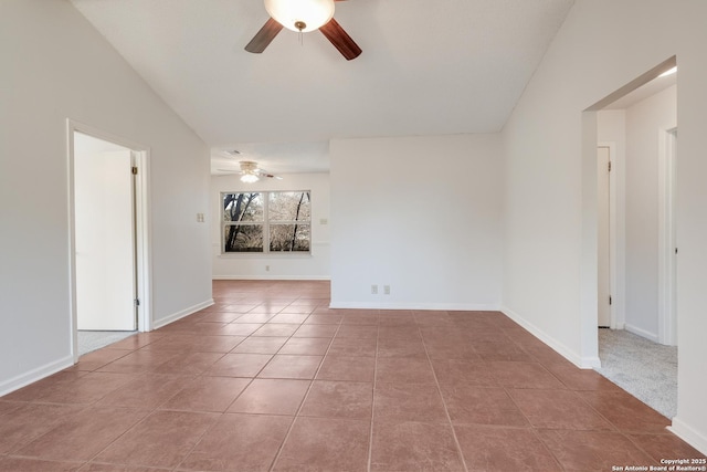 empty room with ceiling fan, lofted ceiling, and tile patterned flooring