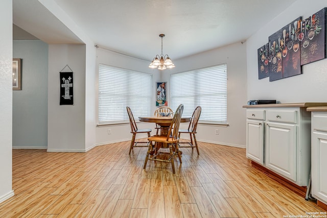 dining room featuring a notable chandelier, a healthy amount of sunlight, and light wood-type flooring