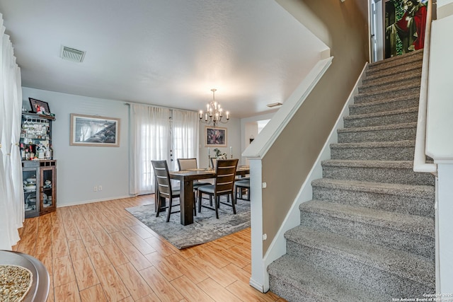 dining space with a notable chandelier and light hardwood / wood-style flooring