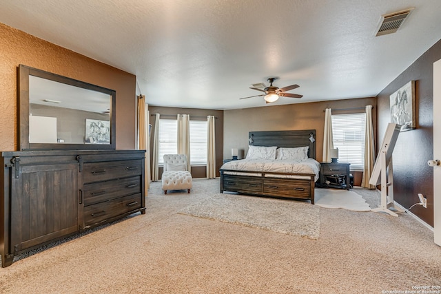 bedroom featuring light carpet, a textured ceiling, and ceiling fan