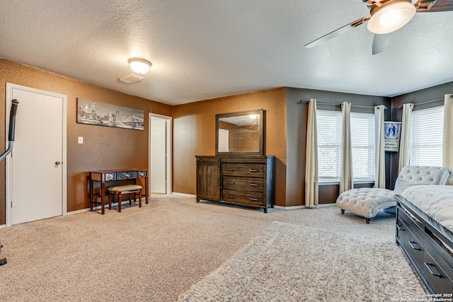 carpeted bedroom featuring a textured ceiling and ceiling fan