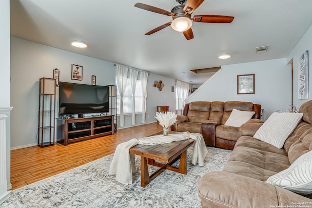 living room with light hardwood / wood-style floors and ceiling fan