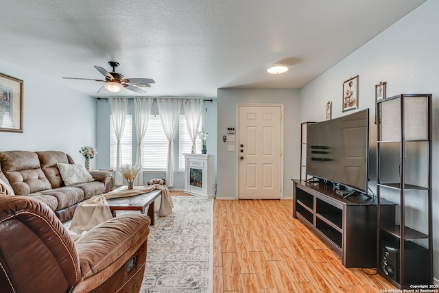 living room with ceiling fan, hardwood / wood-style floors, and a textured ceiling