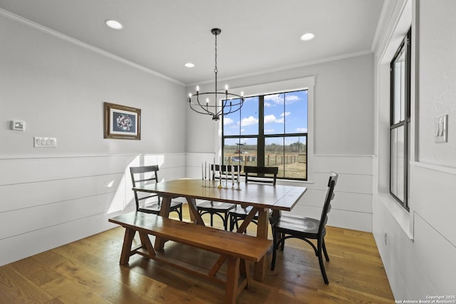 dining space featuring hardwood / wood-style floors, ornamental molding, and a chandelier