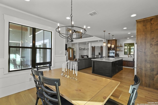 dining area with an inviting chandelier, light hardwood / wood-style flooring, and a healthy amount of sunlight