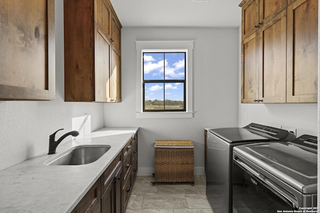 laundry room featuring cabinets, sink, and washer and dryer