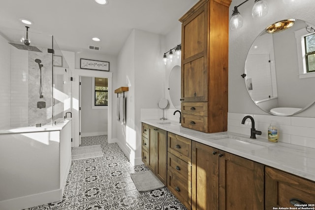 bathroom featuring a shower with door, vanity, tile patterned flooring, and decorative backsplash