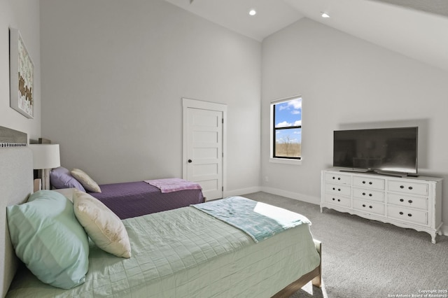 carpeted bedroom with high vaulted ceiling