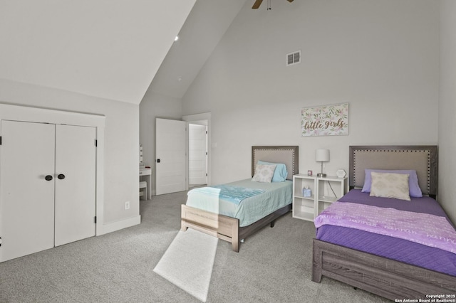 carpeted bedroom with ceiling fan, high vaulted ceiling, and a closet