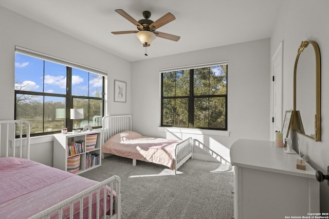 bedroom with ceiling fan, carpet flooring, and multiple windows