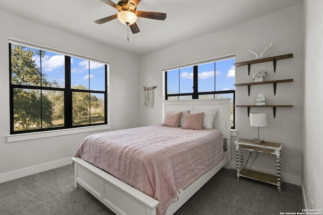 bedroom featuring multiple windows, ceiling fan, and dark colored carpet