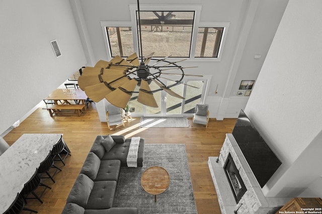 living room with a towering ceiling and wood-type flooring