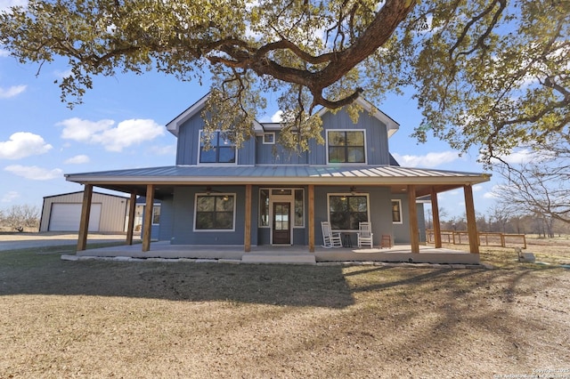 view of front facade featuring a porch, a garage, and an outdoor structure