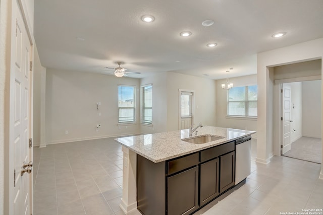 kitchen featuring dishwasher, an island with sink, sink, light stone countertops, and dark brown cabinets