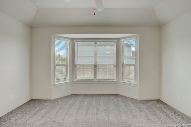 carpeted spare room featuring lofted ceiling and ceiling fan