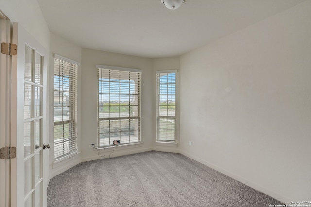 carpeted spare room with a healthy amount of sunlight