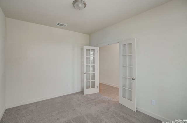 carpeted empty room featuring french doors