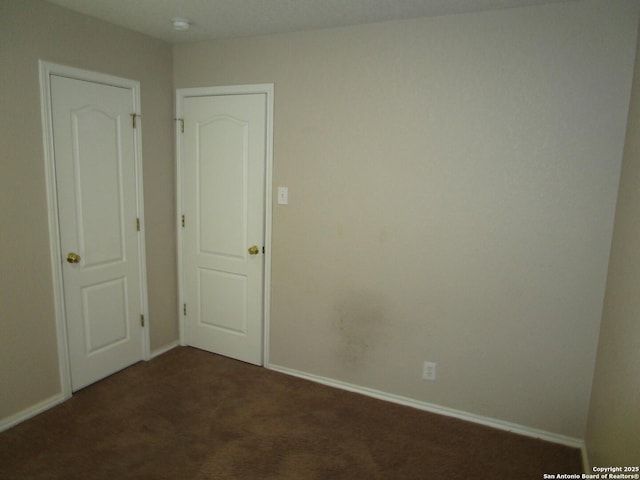 unfurnished room with dark colored carpet