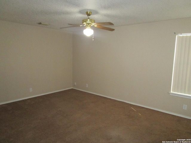 empty room featuring dark carpet, a textured ceiling, and ceiling fan