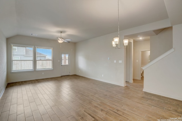 spare room with vaulted ceiling, ceiling fan with notable chandelier, and light hardwood / wood-style flooring