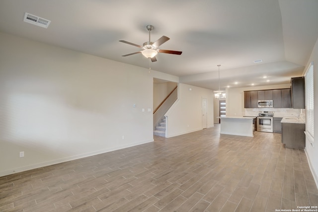 unfurnished living room with ceiling fan with notable chandelier