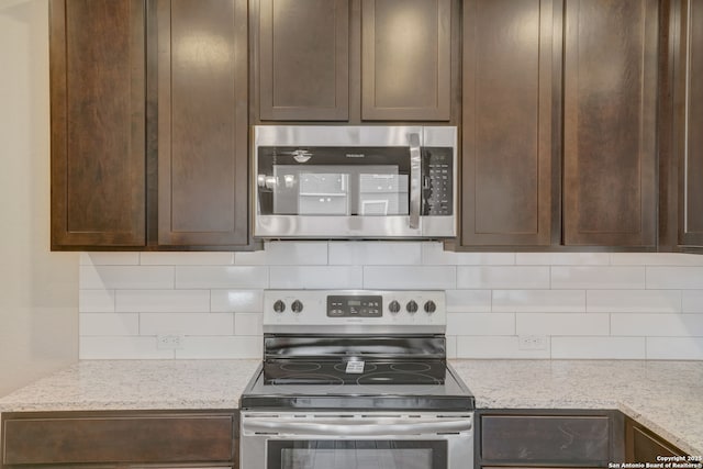 kitchen with tasteful backsplash, stainless steel appliances, and light stone counters